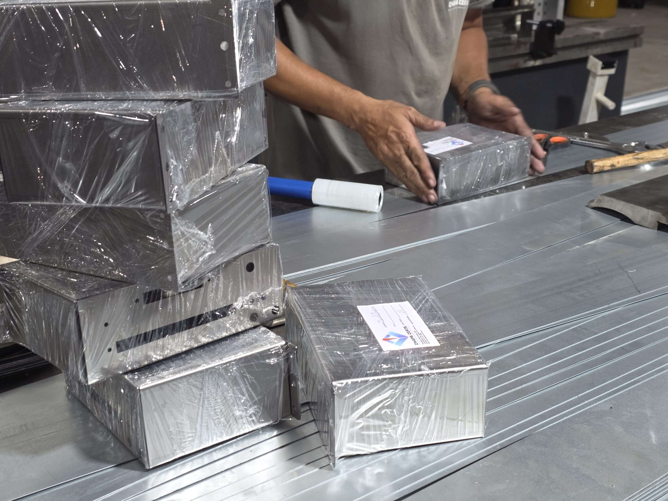 Peças metálicas produzidas pela Chapa Certa — aço e alumínio cortados e dobrados sob desenho técnico