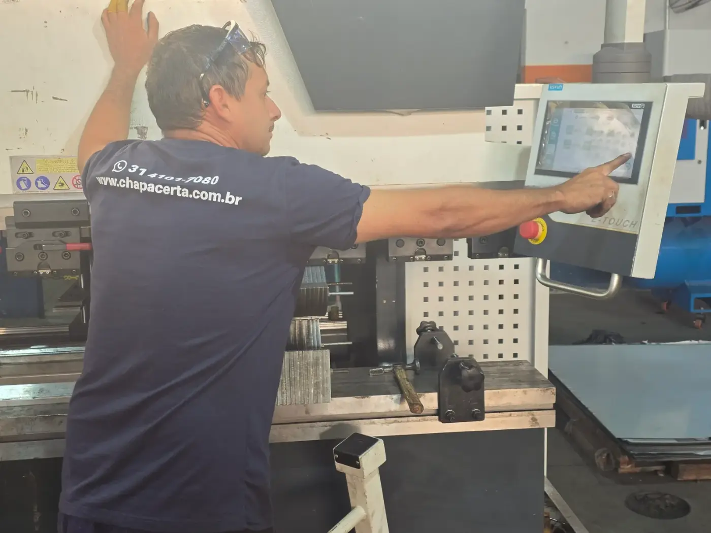 Operador programando a dobradeira CNC