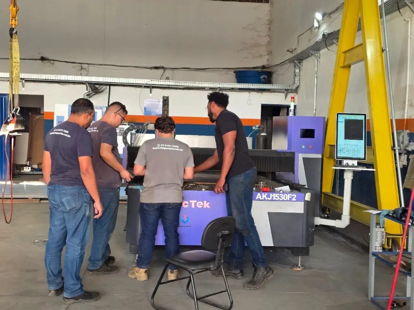 Operadores em treinamento na máquina de corte a laser